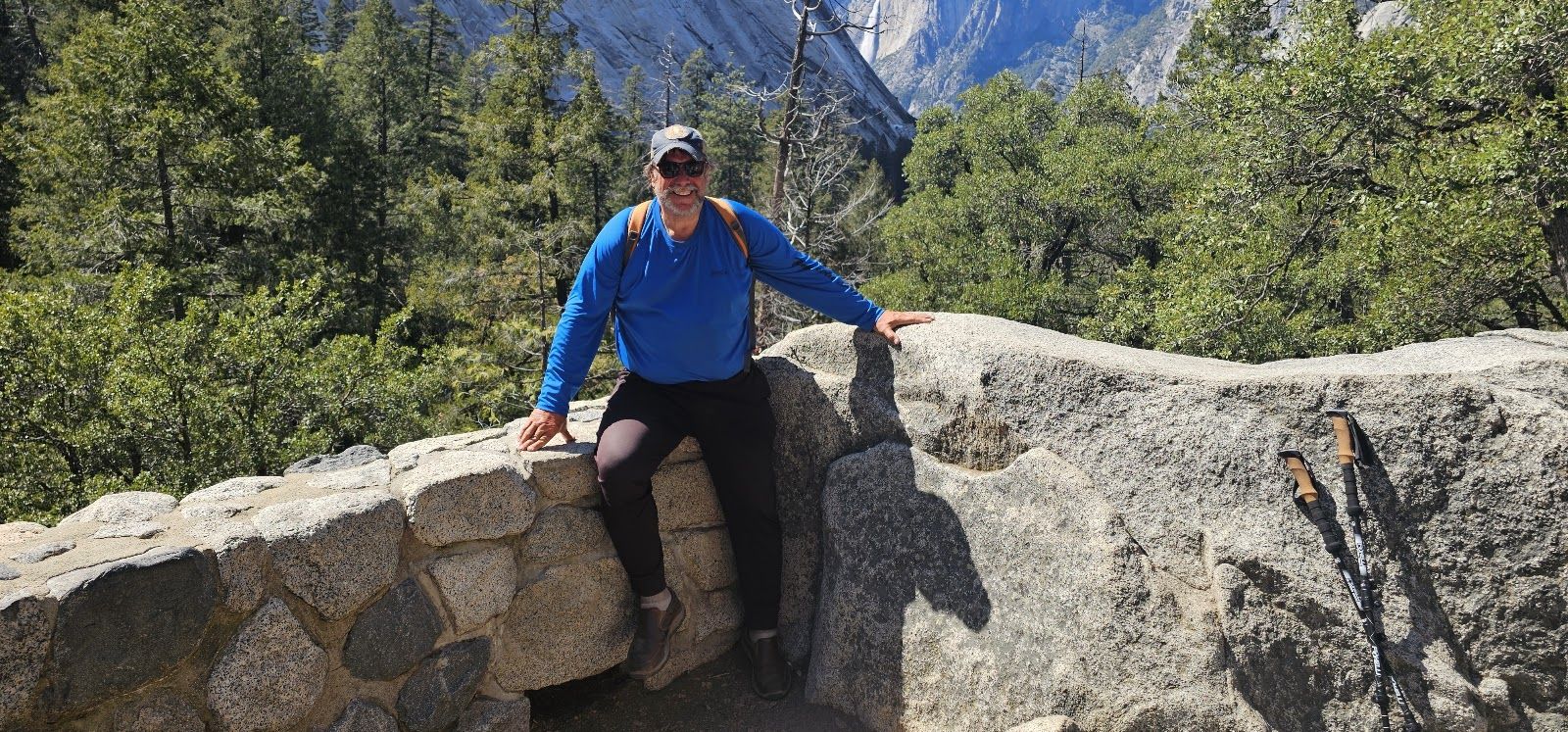 Mark Fugel on a mountain trail, granite peaks and pines behind him